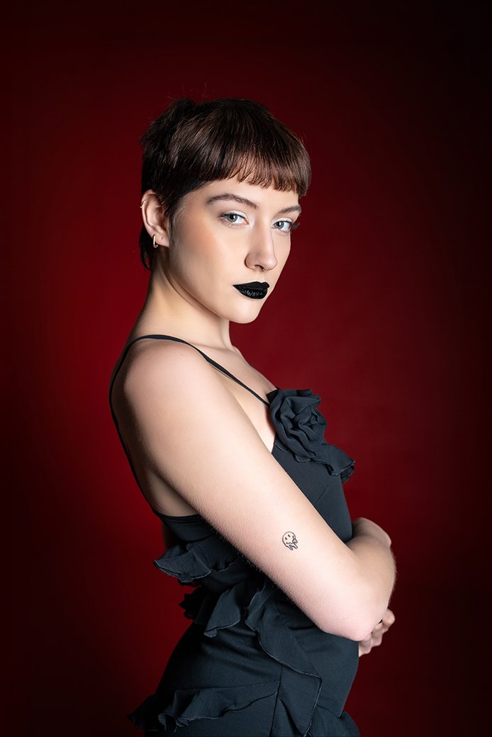 lilo milova studio portrait half body dark red background black dress and make up